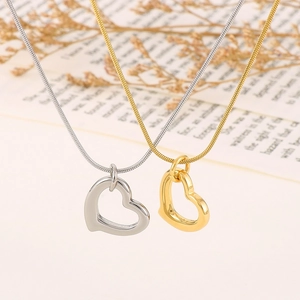 Macro shot of gold and silver hollow heart pendants on fine snake chains for women