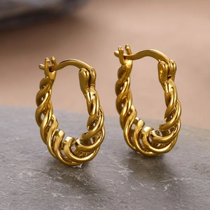 Detailed close-up of 18k gold plated twisted square hoop earrings on a stone surface