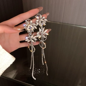 Detailed view of silver flower tassel earrings with crystals for evening party wear