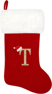 Detail showing red velvet Christmas stocking with golden letter T embroidery and white fur trim