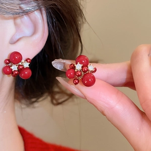 Macro detail of red firework stud earrings with gold plating and sparkling zircon stones
