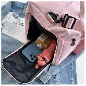 Dettaglio della tasca laterale del borsone sportivo in nylon rosa con ampia capacità