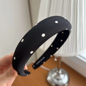 Detailed close-up of handmade wide padded satin headband with white polka dot patterns