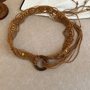 Detail of handmade woven waist chain with wood beads and decorative long tassels
