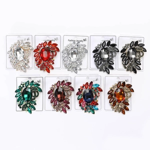 Detailed macro view of nine colored alloy flower brooches with oval crystals on display cards