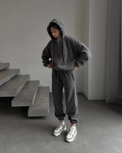 Dettaglio di felpa con cappuccio grigio scuro e pantaloni sportivi in morbido pile