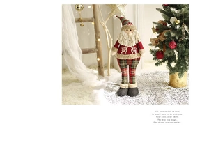 Detail of plush Santa Claus figure with elk pattern sweater and plaid pants decoration