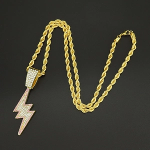 Close-up of a gold twist chain necklace with a lightning bolt pendant in pink and white crystals