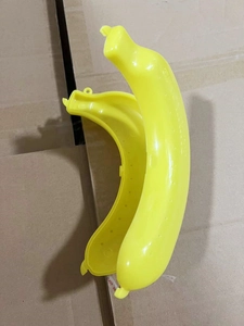 Detail of open yellow plastic banana case guard protector on a cardboard background