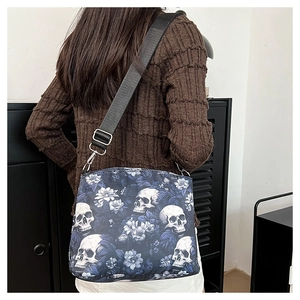 Detail of dark blue skull and floral jacquard pattern on a stylish crossbody bucket bag