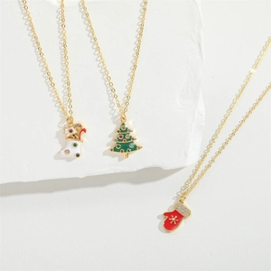Three gold necklaces featuring colorful Christmas enamel charms with small crystals