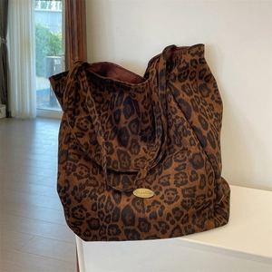 Detail view of large leopard print tote bag with Sazakha logo and canvas fabric texture