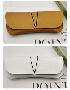 Detail of yellow and white leather sunglass cases with elastic button closure