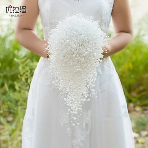 Macro shot of white pearl bridal bouquet with elegant cascading waterfall fringe detail