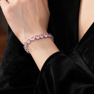 Macro view of claw-set pink oval gemstones on a silver-plated link bracelet