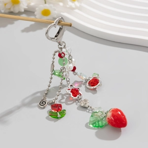 Dettaglio portachiavi con fragola e fiori e chiusura a cuore per borse o telefoni