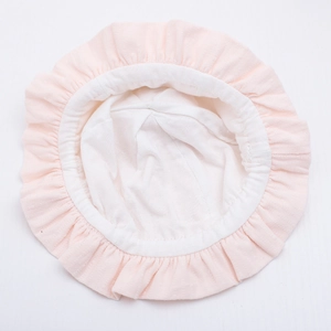 Close-up of baby sun hat with ruffled edges and soft pink cotton fabric detail
