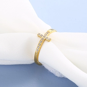Bague croix en acier inoxydable doré avec zircons blancs sur fond de soie blanche