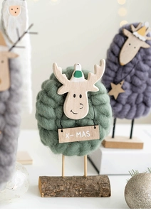 Detailed view of handmade wool felt reindeer decorations with natural wooden bases