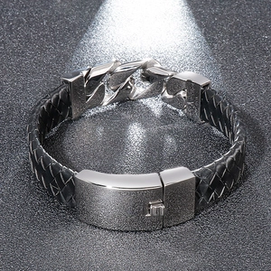 Close-up of men's black braided leather bracelet with silver steel chain and magnetic clasp