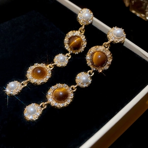 Detail of vintage long drop earrings with brown tiger eye stone and white pearls