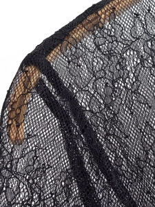 Close-up of black lace fabric on wooden hanger showing intricate mesh texture details