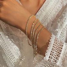 Wrist view of a 5-piece gold-plated tennis bracelet set with sparkling crystal stones