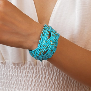 Detail shot of multi-layer blue glass bead wrap bracelet on wrist with gold accents