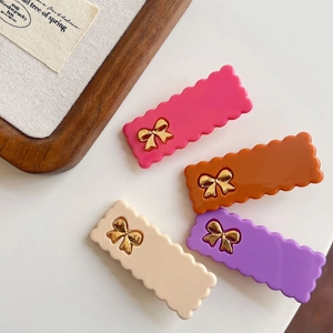Barrettes rectangulaires ondulées pastel avec nœuds dorés sur un fond minimaliste