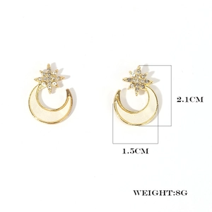 Detail showing dimensions of star and moon earrings with gold trim and white enamel