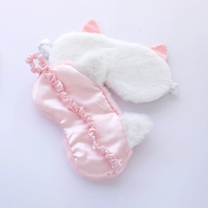 Detail of plush cat ear eye mask and pink silk texture with elastic strap