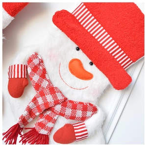 Macro shot of 3D plush snowman Christmas stocking with knitted stripe and check details