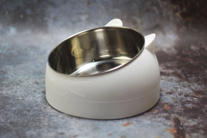 Macro shot of stainless steel pet bowl insert with ergonomic tilted cat ear white base