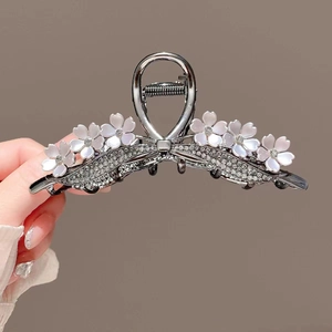 Macro detail of gunmetal floral hair claw clip featuring white pearls and rhinestones