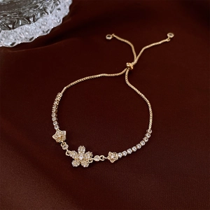 Macro detail of gold flower bracelet with zircon stones and adjustable drawstring clasp