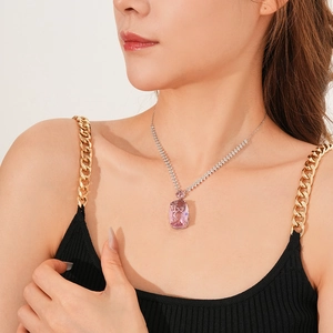 Macro shot of silver necklace featuring pink rectangular zircon pendant on a model