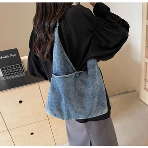 Lifestyle view of a spacious blue denim tote bag worn as a shoulder bag on a model