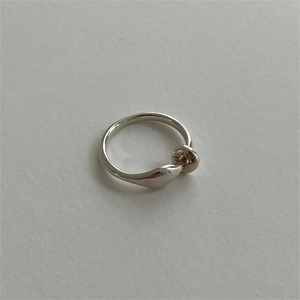 Detailed view of 925 sterling silver ring with polished twisted knot design on gray background