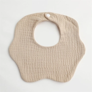 Detail of a beige petal-shaped baby bib with soft wrinkled gauze cotton and snap button