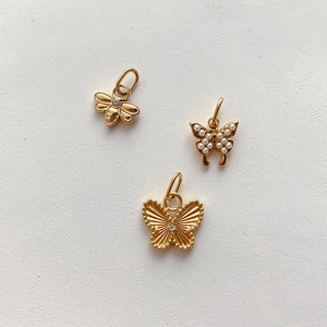 Detail von 18K vergoldeten Anhängern mit Bienen- und Schmetterlingsdesign und Kristallen