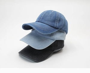 Three stacked denim baseball caps in dark blue, light blue, and black colors