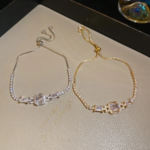 Macro detail of luxury square zircon bracelets in gold and silver with adjustable chains