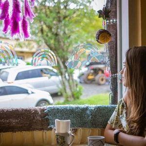 Close-up of holographic rainbow prism window stickers reflecting sunlight on a glass pane