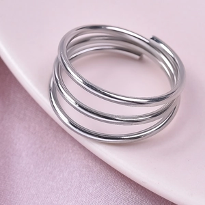 Detailed close-up of a silver triple-layered stainless steel ring on a pink display plate