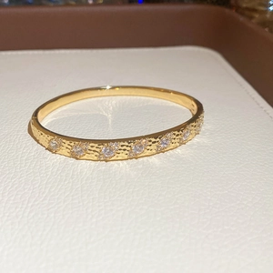 Détail du bracelet plaqué or avec texture martelée et incrustations de zircons étincelants