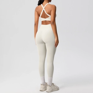 Vista trasera del conjunto de yoga crema con sujetador deportivo cruzado y leggings altos
