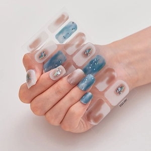 Detailed view of blue-brown gradient nail stickers with geometric gems and rhinestones