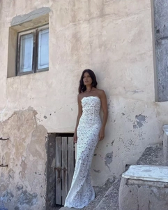 Detailweergave van witte bloemenkant op een strapless nauwsluitende maxi-jurk