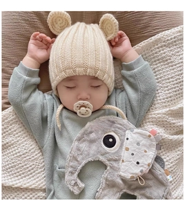 Detail of gray plush elephant security blanket with colorful tags for baby soothing