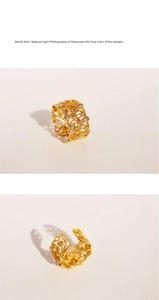 Macro detail shot of vintage gold lace open ring with hollow patterns and white zircons